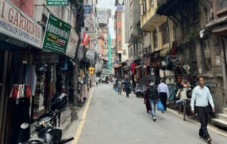 A city street in Kathmandu, with people walking on it. 