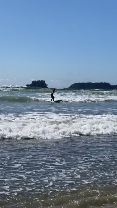 A girl surfing on a small wave.