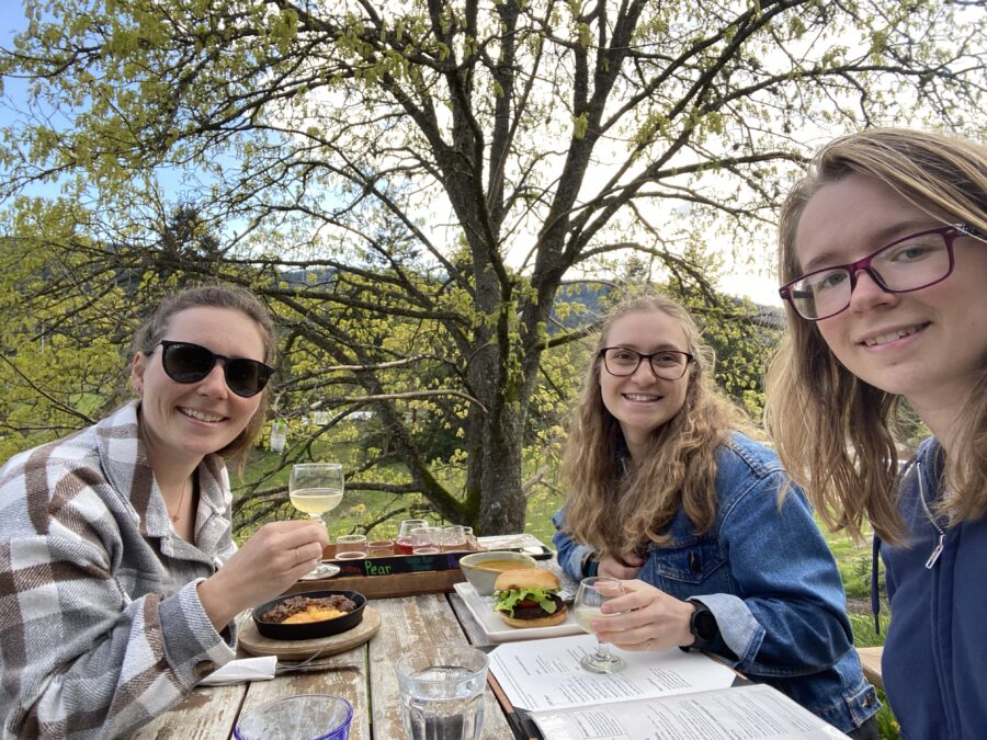 Three girls enjoying a meal and sampling cider at Salt Spring Wild Cidery on Salt Spring Island, BC.