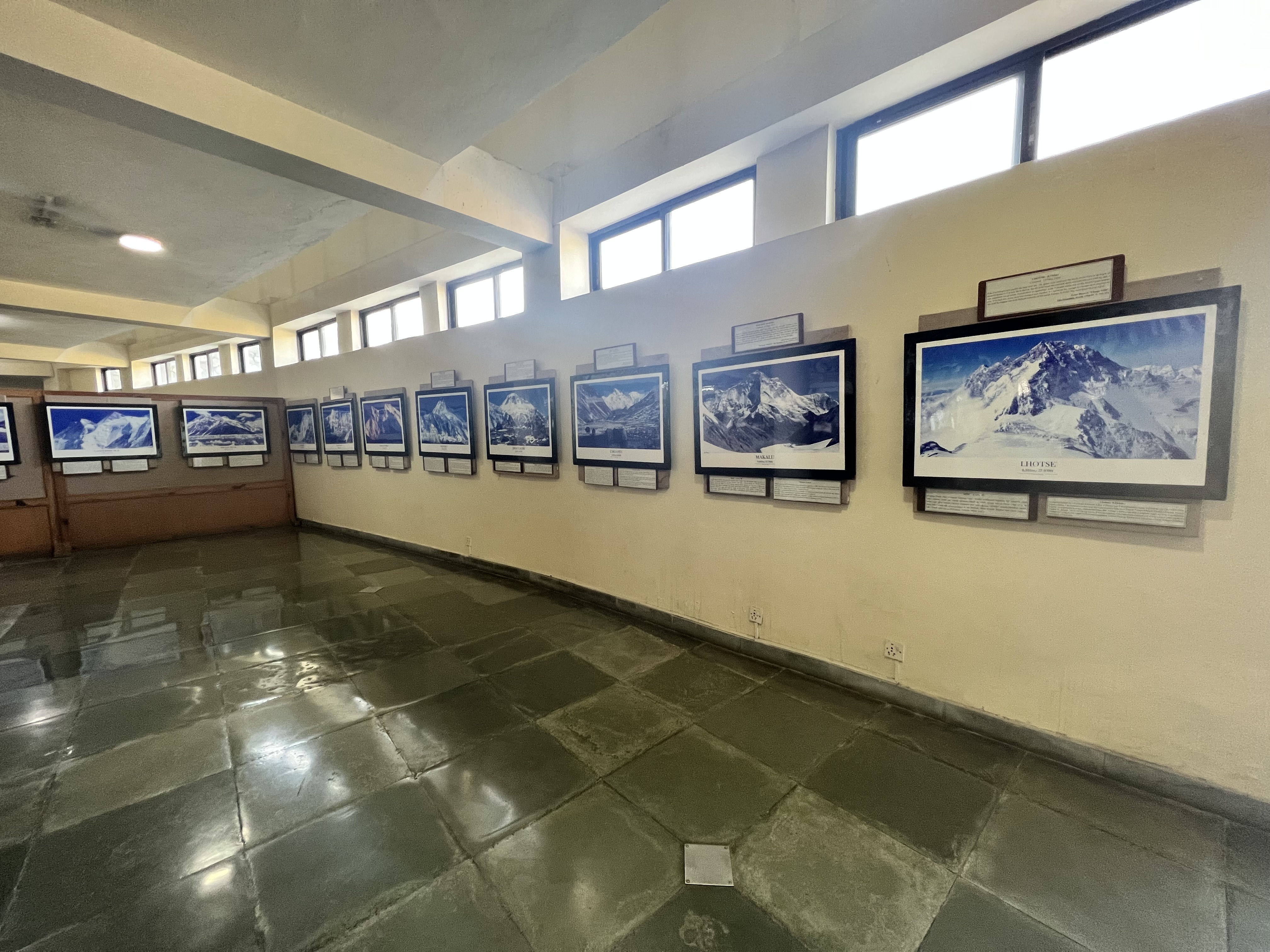 A wall full of photos of each of the largest mountains in the world with descriptions in the International Mountain Museum in Pokhara.