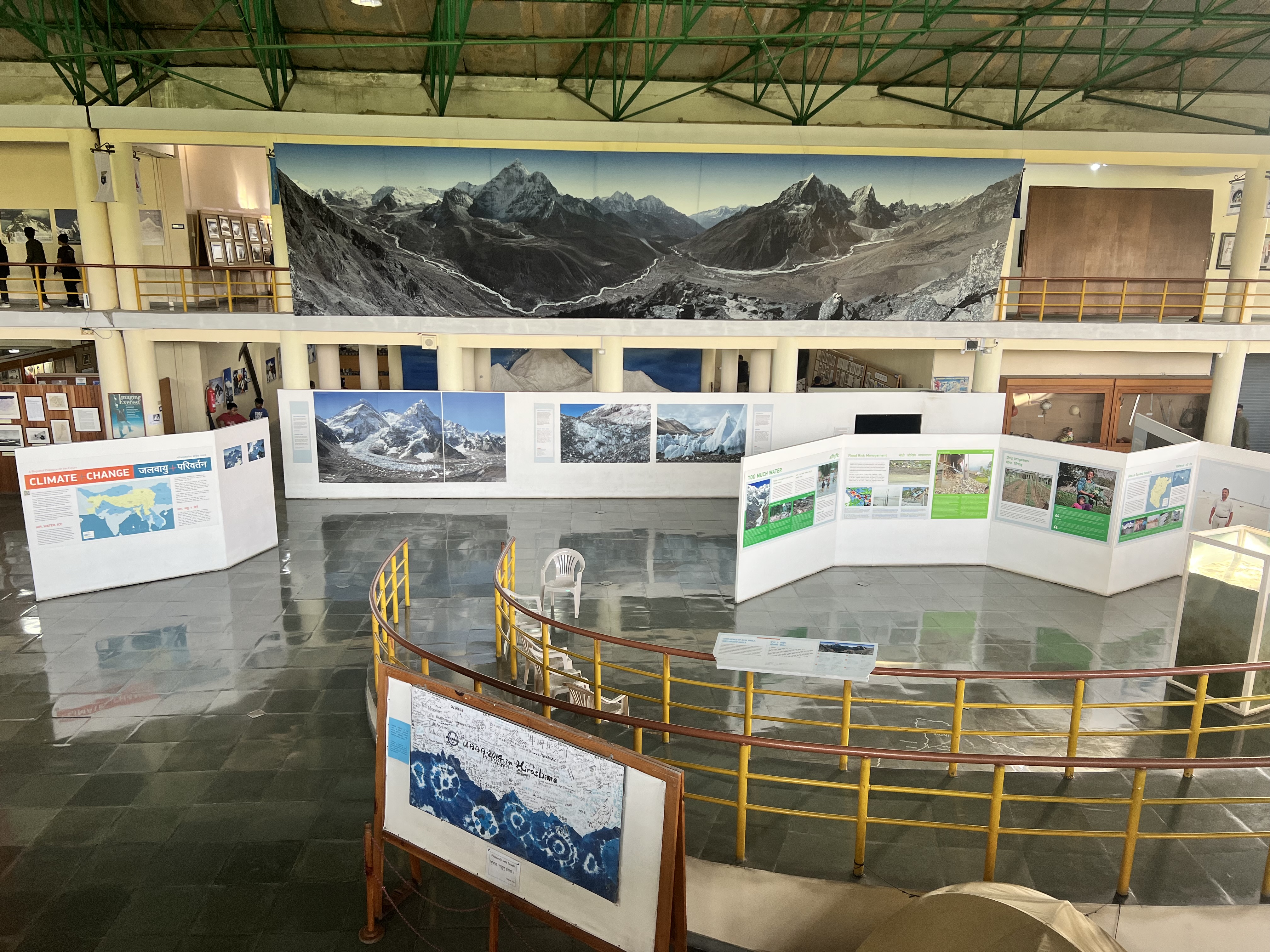 The inside of the International Museum in Pokhara.  Shows a large photo of mountains on the wall and large displays with pictures and text.