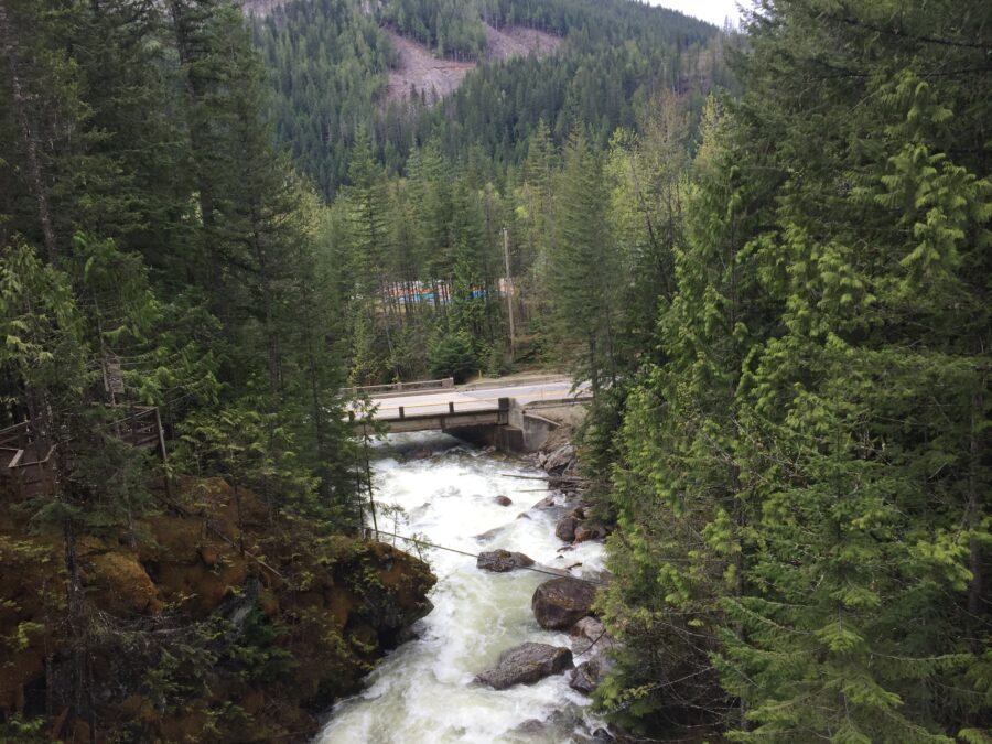 A fast flowing river with a road bridge across it. 