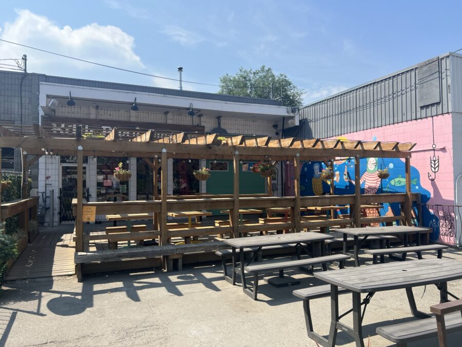 The outside of Kettle River Brewing. You can see an outdoor patio, and a mural on the wall. 