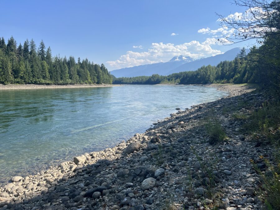 The Columbia river as seen from the bottom of Moses Falls, with mountains in the background. 