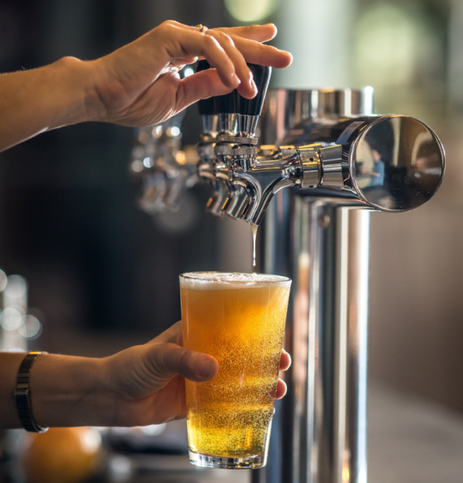 Someone pouring a draft beer from a tap.