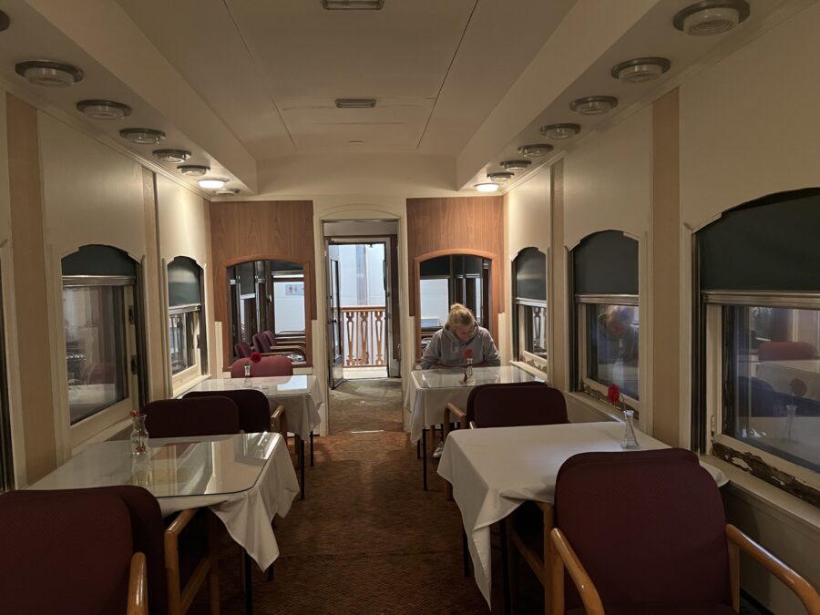 A man sitting at a table in a train dining car. 