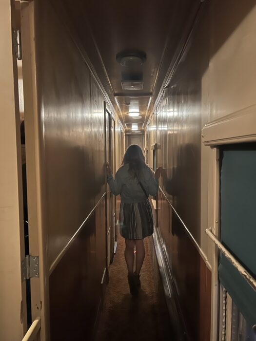 A girl walking through a train hallway inside the Revelstoke Railway Museum