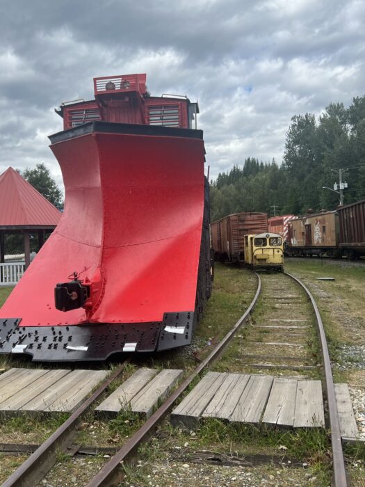 The front of a red train in the trainyard of the Revelstoke Railway Museum