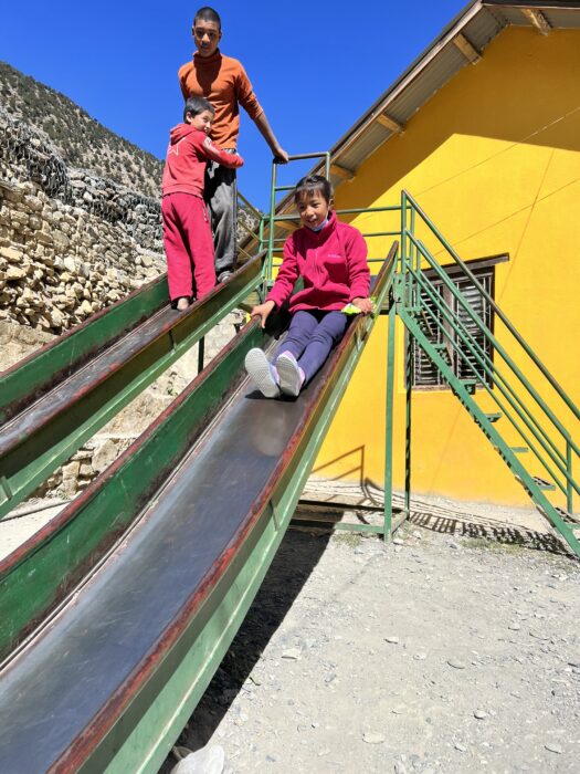 A girl sliding down a metal slide