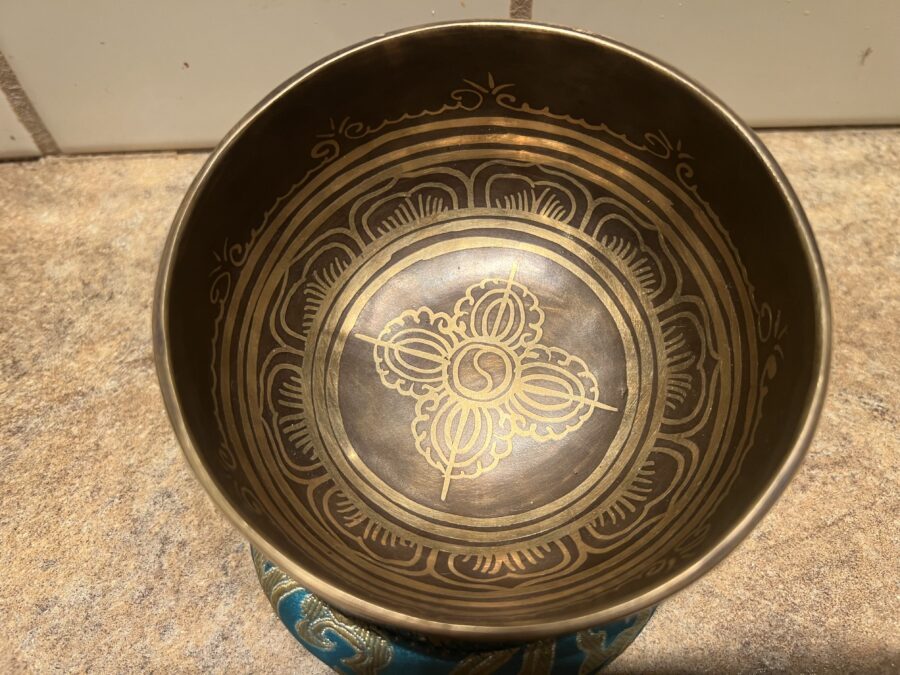 The inside view of a singing bowl with beautiful carvings and symbols engraved. 