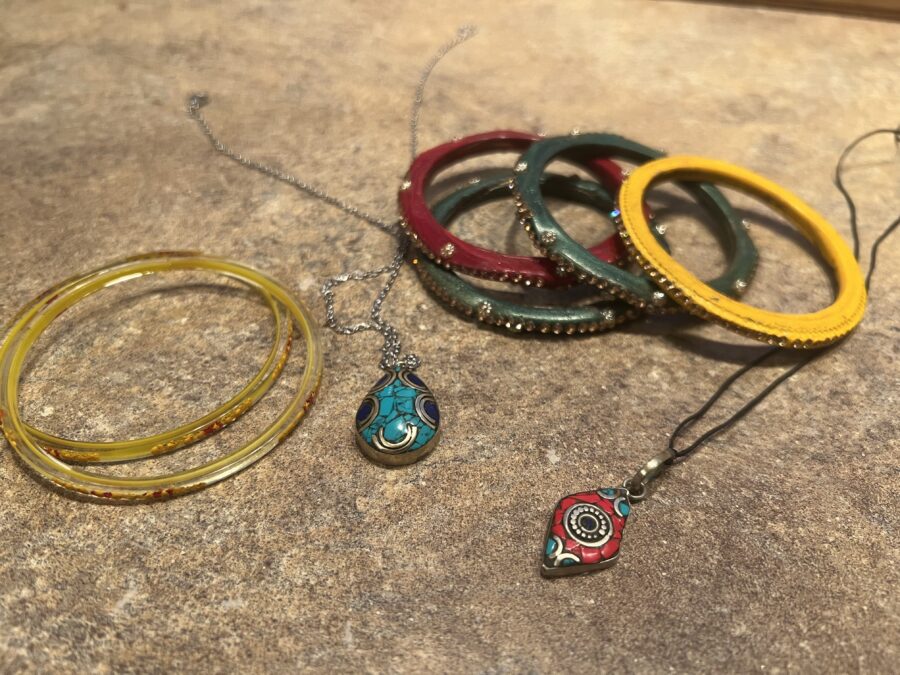 Two necklaces and several bracelets/bangles arranged on a countertop