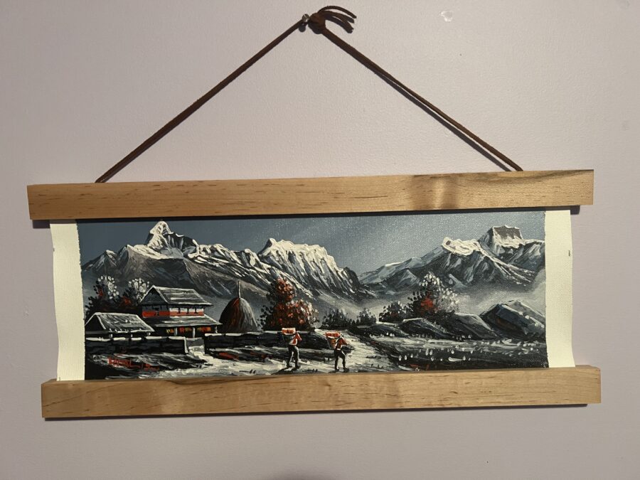 An acrylic painting of the Himalayas, hanging on a wall. 